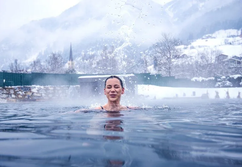 Venkovní termální bazény Alpentherme kouřící se v zimě.